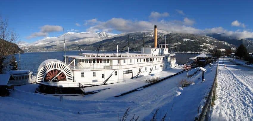 Historic SS Moyie sternwheeler in Kaslo British Columbia surrounded by snow with mountains and Kootenay Lake behind it