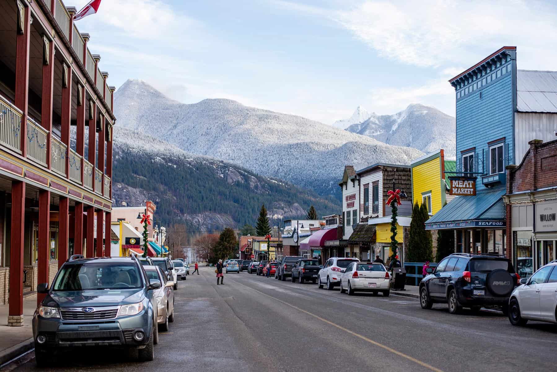 Historic downtown Kaslo BC in winter with colourful storefronts and snow-covered mountains in the background